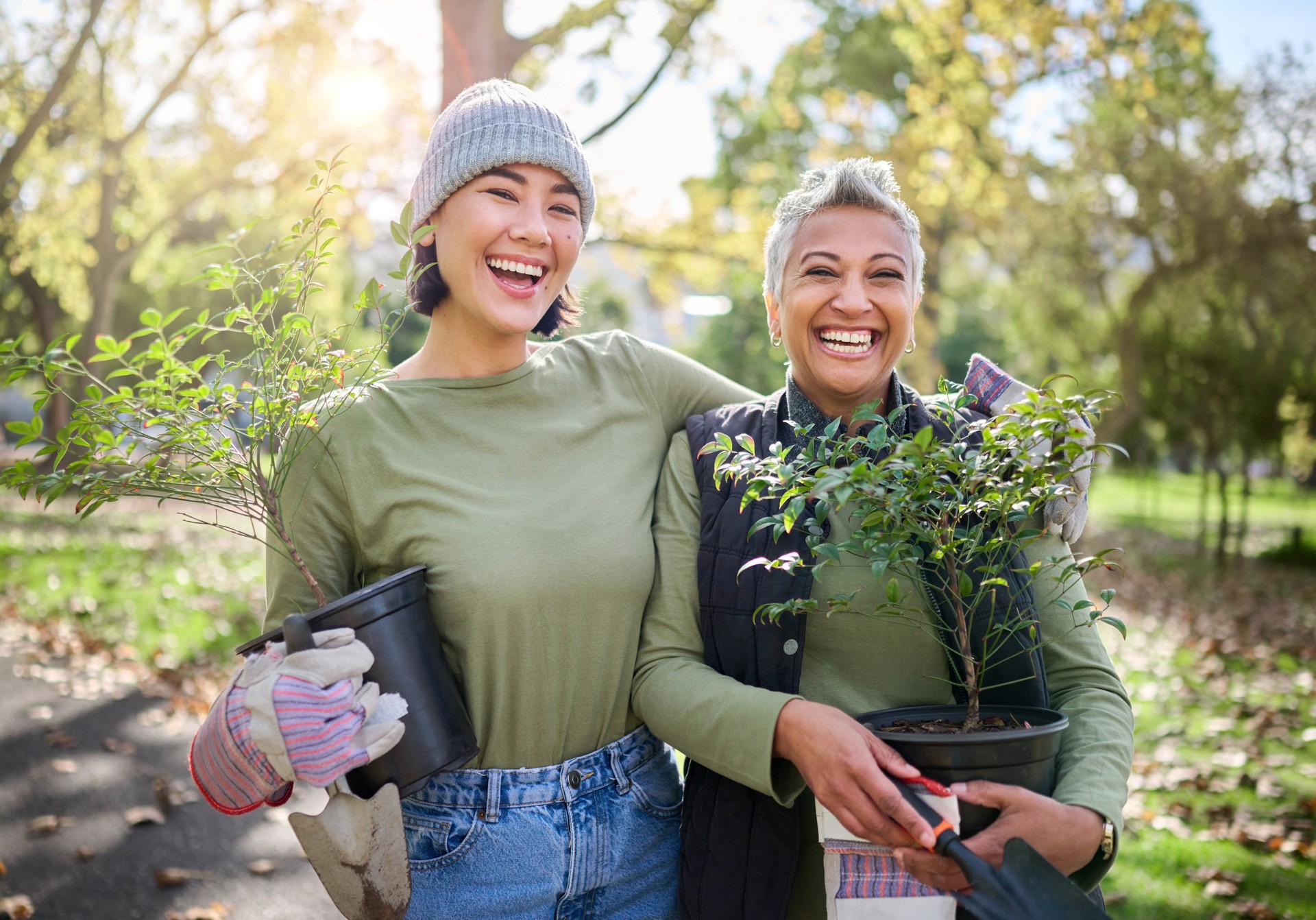 Portrait, flowers and women volunteering in park for community, outreach or programme together. Environment, charity and friends volunteer in forest for gardening project, happy and smile in nature